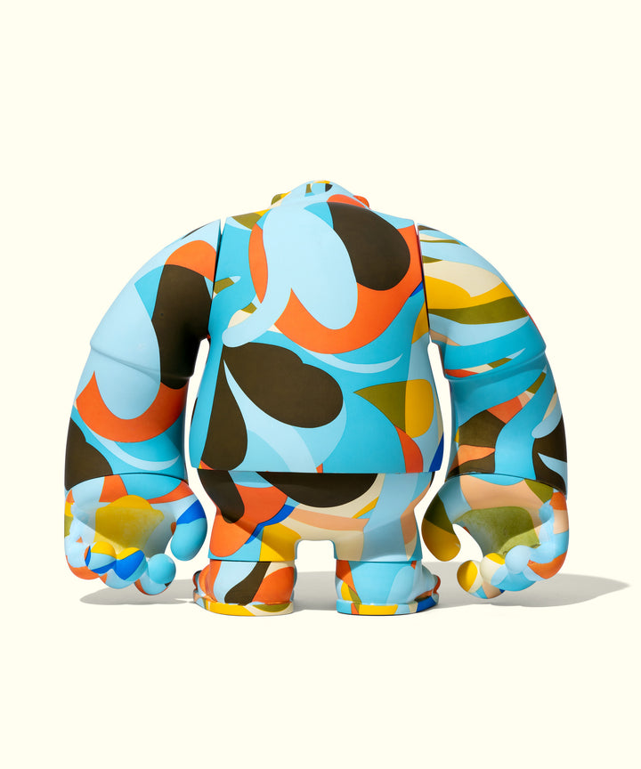 Colorful abstract vinyl figure with curvy shapes in blue, orange, yellow, and brown, featuring a plump body and short limbs. Artistic collaboration showcasing a kaleidoscopic design inspired by Andy Davis for Sun Bum