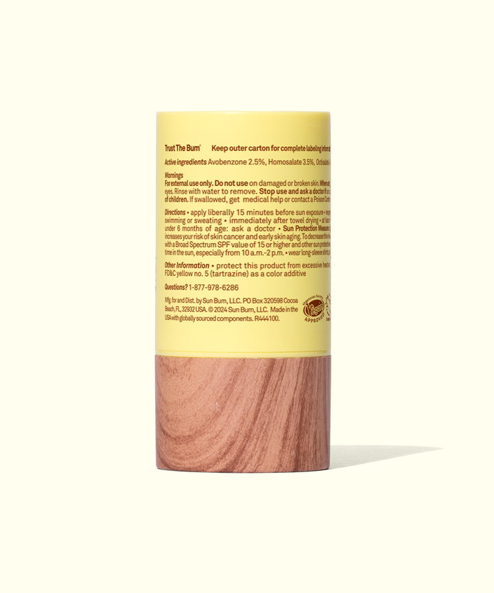 Cylindrical sunscreen stick with yellow top and wooden base, displaying product information on label. Easy-to-use SPF 40 protection for face and body by Sun Bum